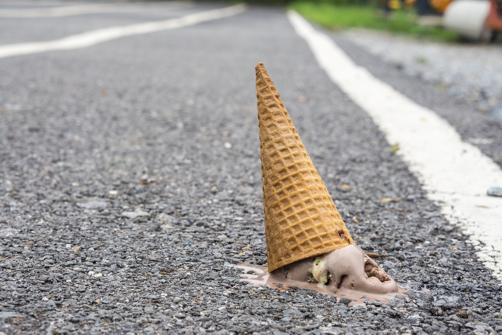 Ice cream on the ground. (selective focus)., chocolate ice cream cone dropped on the concrete floor and melt on ground. with copy space for text. dirty concept. lost concept.