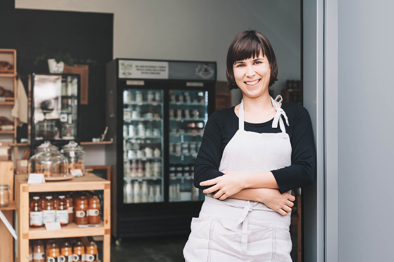 A local shopkeeper stands at the door of her business.