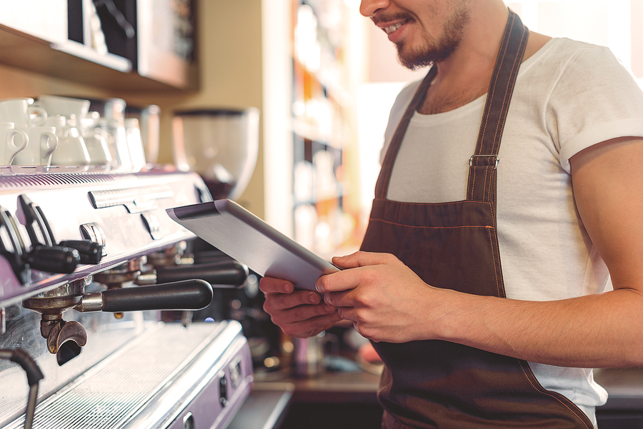 digital tablet in hands of a small business owner in the kitchen